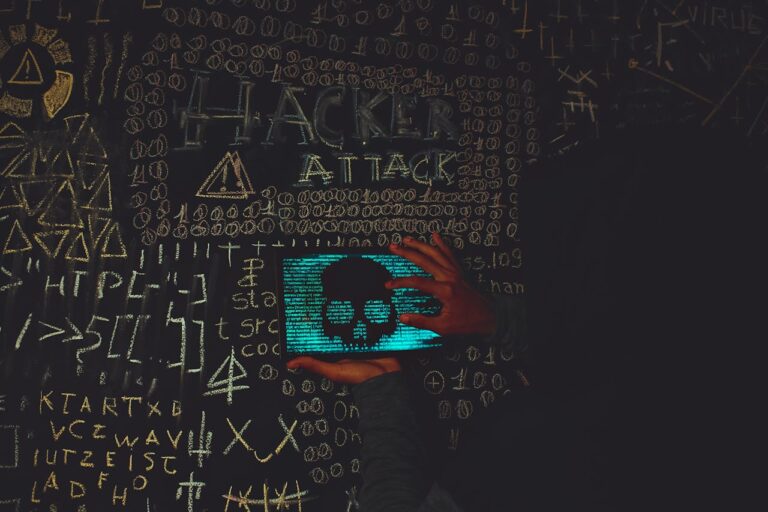 A hacker in a black hoodie using a tablet displaying a skull, surrounded by chalk symbols and 'Hacker Attack' text.